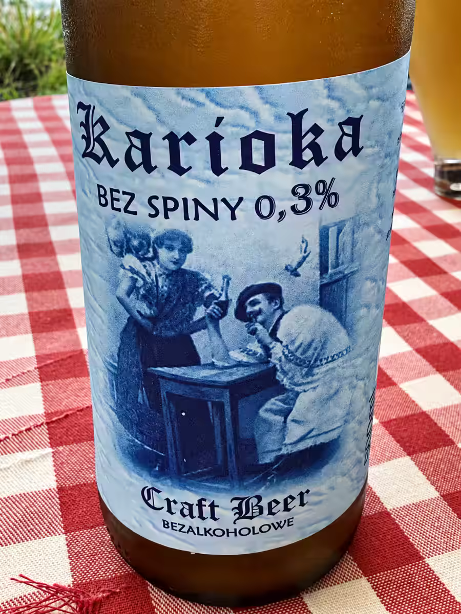 Butelka piwa Karioka „Bez spiny” 0,3%, kraftowe bezalkoholowe, na stole w czerwoną kratę